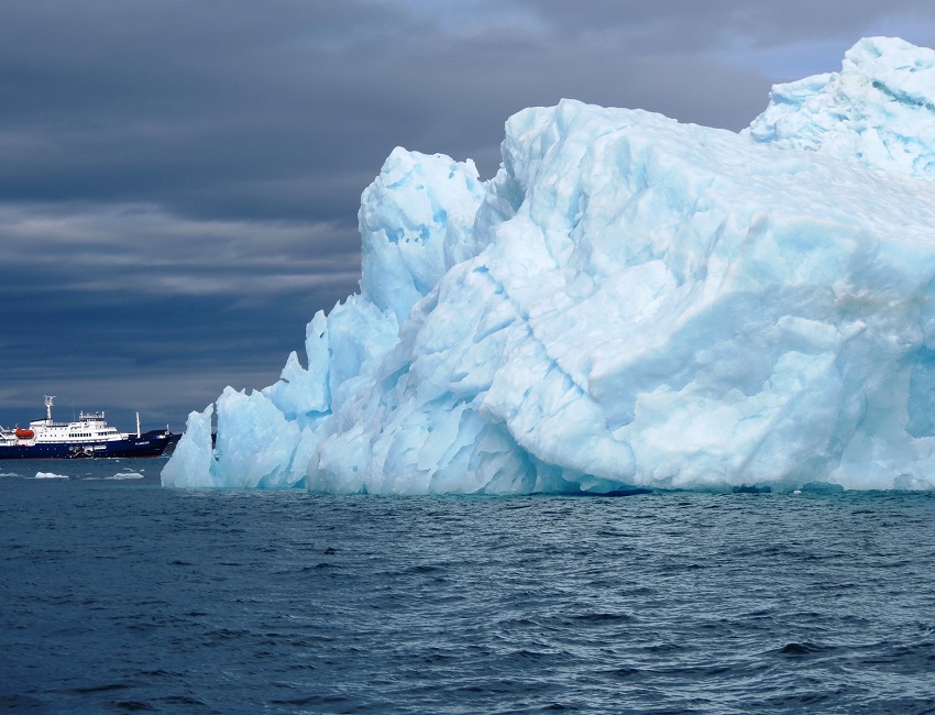 Bateau d'expédition devant un immense iceberg - Groenland | Les Mondes Polaires